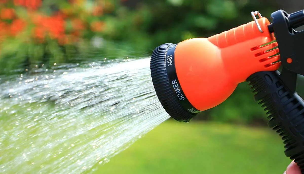 orange garden hose spraying water
